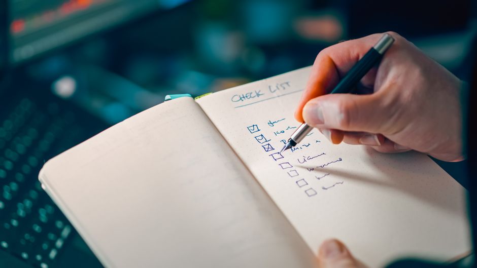 Ruka píše checklist do zápisníku — vzorová struktura zásad cookies krok za krokem
